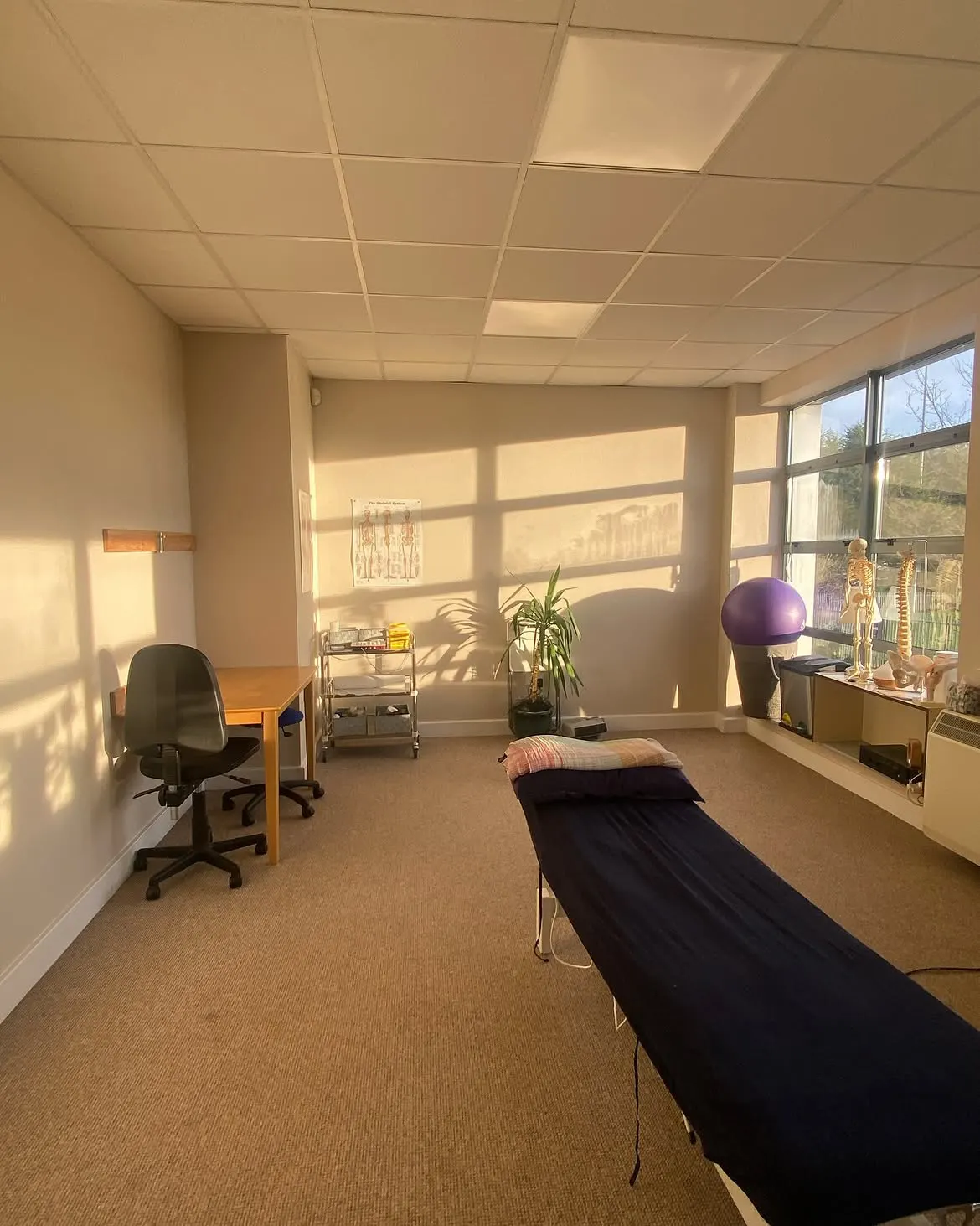 One of the treatment rooms, sunlit, with the plinth ready